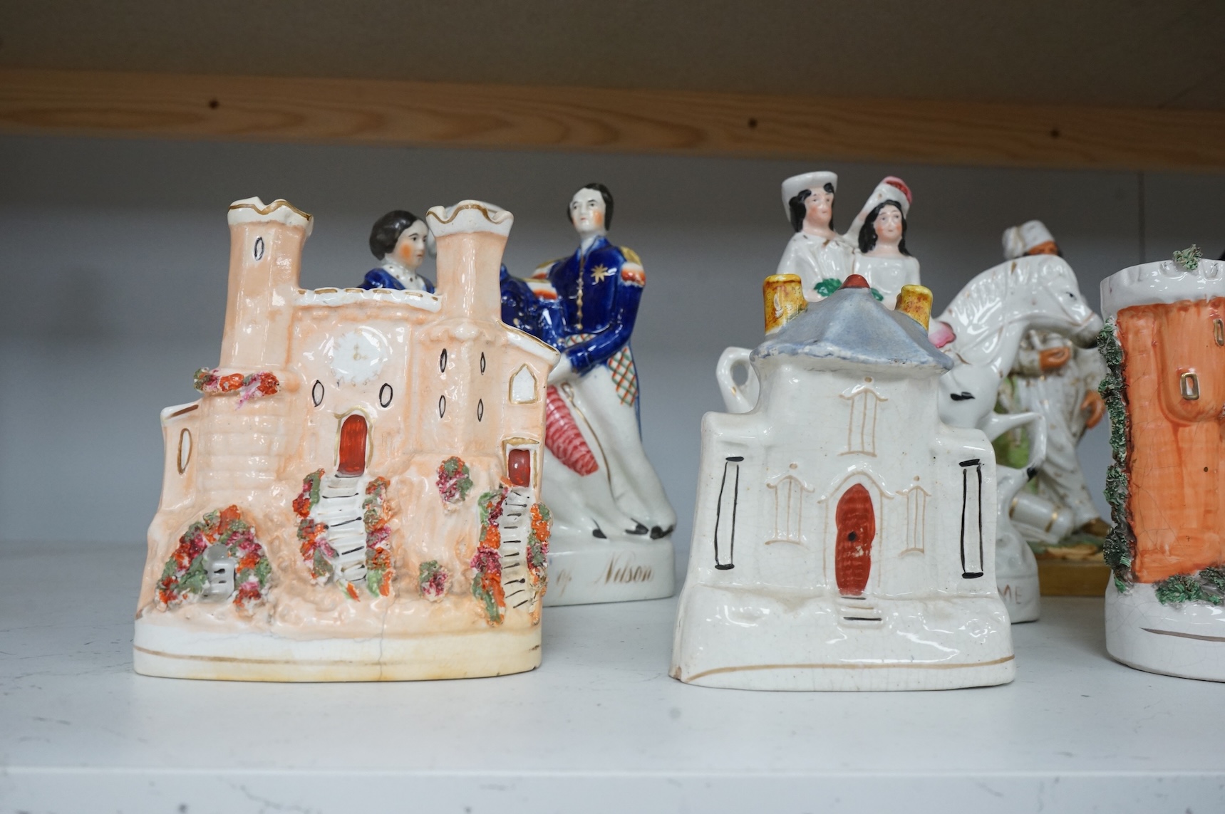 A mid 19th century Paris porcelain figure of a Turkish soldier and six pieces of staffordshire including ‘The Death of Nelson’ group, a 19th century British sailor, ‘Returning Home’ group, and three buildings, tallest 23